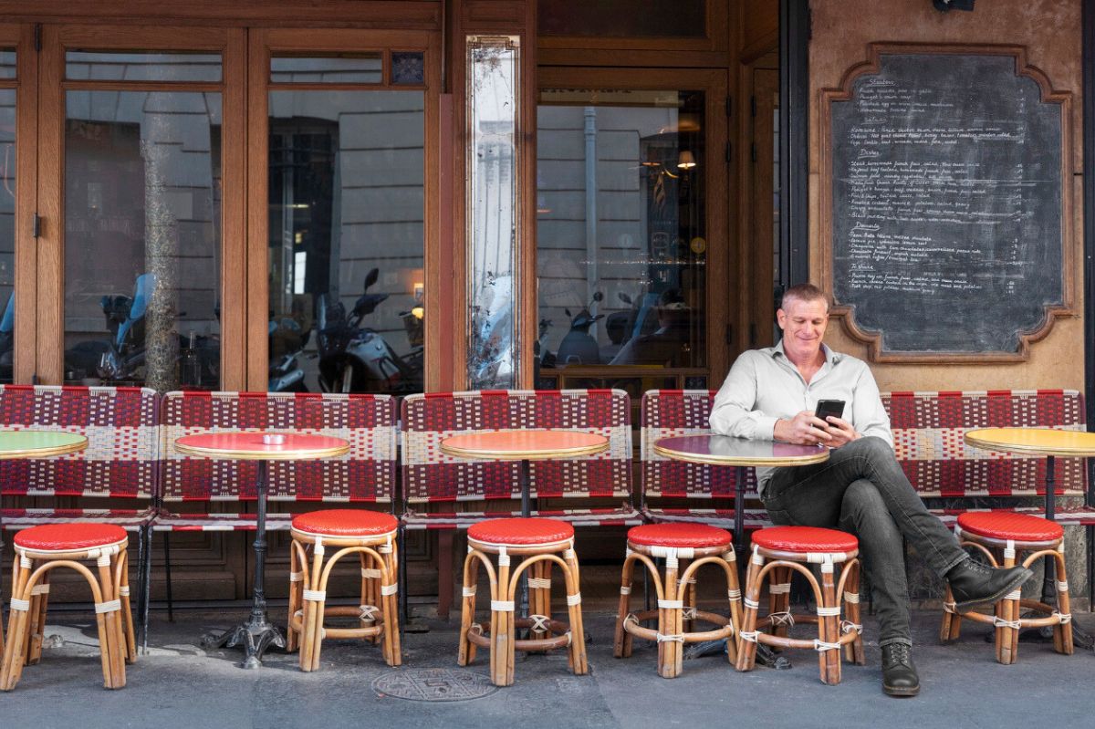 Mężczyzna siedzi na krześle przed restauracją
