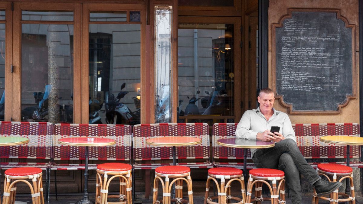 Mężczyzna siedzi na krześle przed restauracją