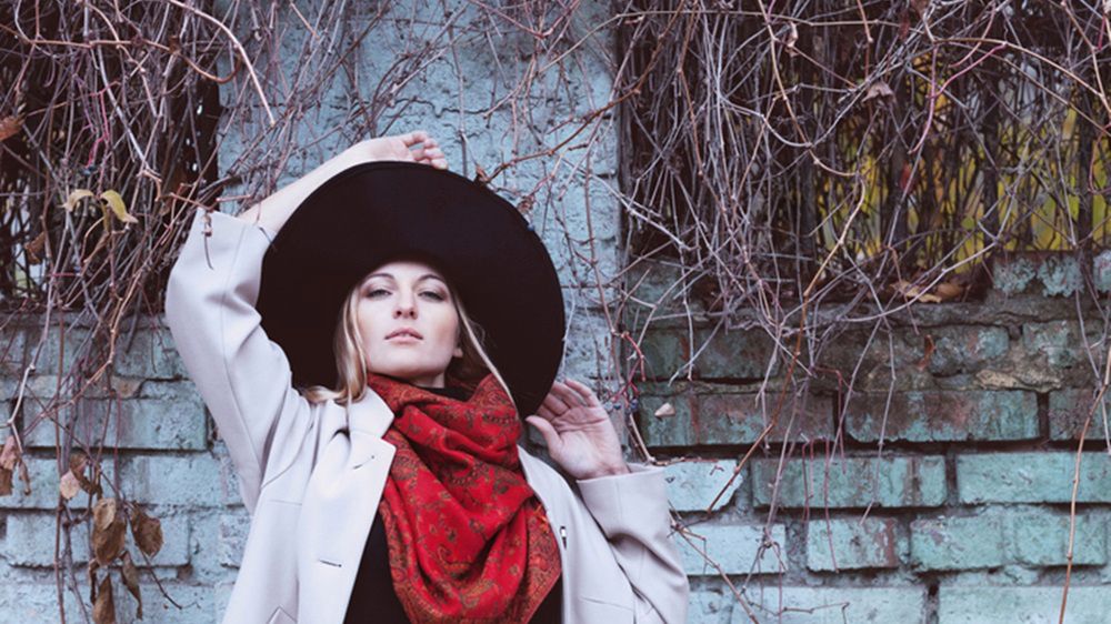 Do wzorzystej czerwonej chusty dobierz cienki płaszcz w jasnym kolorze