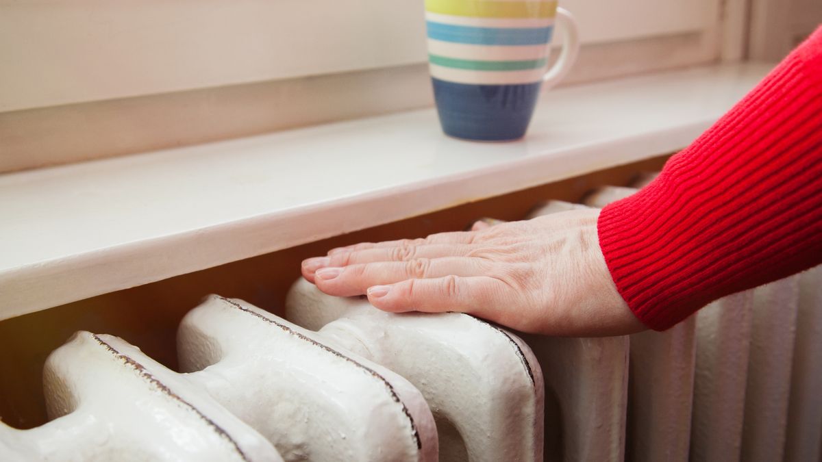hand touching the radiator to check whether heatediron, interior, house, heating, white, warm, radiator, steel, wallpaper, room, hand, attached, sanitary, system, technology, wall, shape, plumbing, maintain, heat, winter, cold, domestic, aluminium, apartment, fingers, indoor, heat-exchanger, heater, red, mug