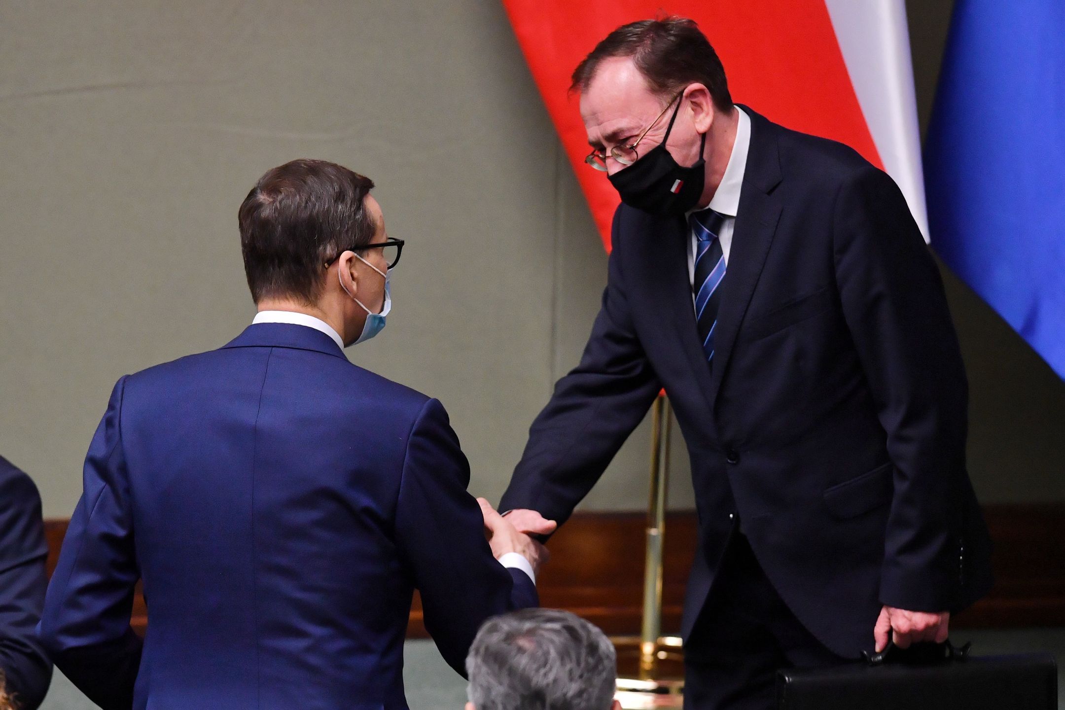 Warszawa, 13.01.2022. Premier Mateusz Morawiecki (L) oraz minister spraw wewnętrznych i administracji Mariusz Kamiński (P) na sali obrad w drugim dniu posiedzenia Sejmu w Warszawie, 13 bm. Sejm odrzucił w czwartek wnioski klubów KO i Polska 2050, by porządek dzienny obrad uzupełnić o informację premiera nt. stanu negocjacji polsko-czeskich ws. Turowa. (kf) PAP/Radek Pietruszka