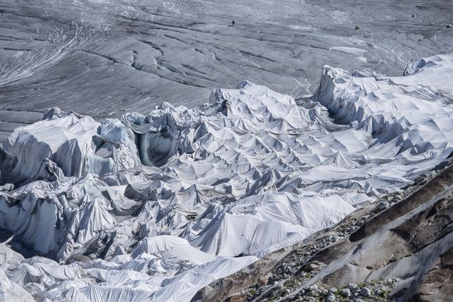 Rhone Glacier covered in blankets
epa10068879 A view of the Rhone Glacier covered in blankets above Gletsch near the Furkapass in Switzerland, 13 July 2022. The Alps oldest glacier is protected by special white blankets to prevent it from melting.  EPA/URS FLUEELER 
Dostawca: PAP/EPA.
URS FLUEELER