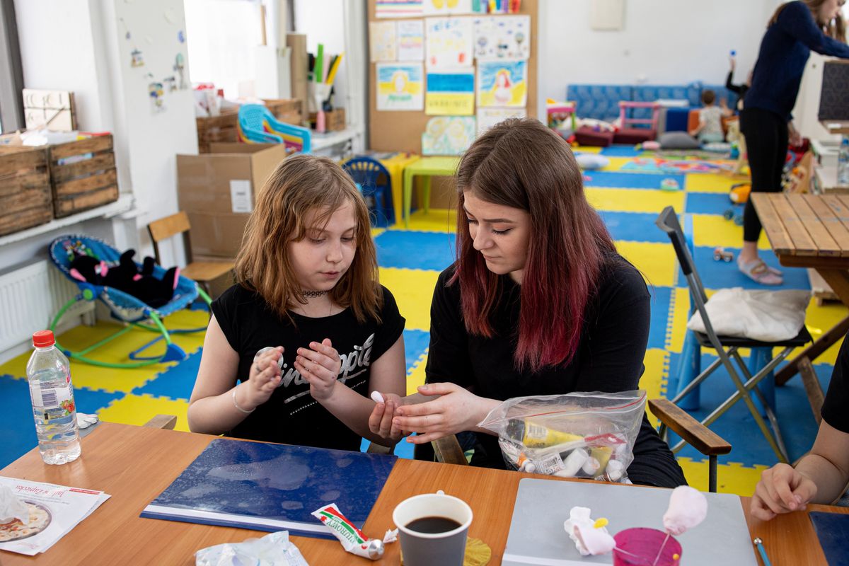 WARSAW, POLAND - 2022/05/12: Young Ukrainian refugee is seen doing handcrafts with the volunteer at the support centre for Ukrainian refugees. Front Pomocy Ukrainie (FPU), a charity group founded by Ukrainians residing in Poland, organize regular activities in their support centre to help Ukrainians integrate into the Polish community. (Photo by Hesther Ng/SOPA Images/LightRocket via Getty Images)