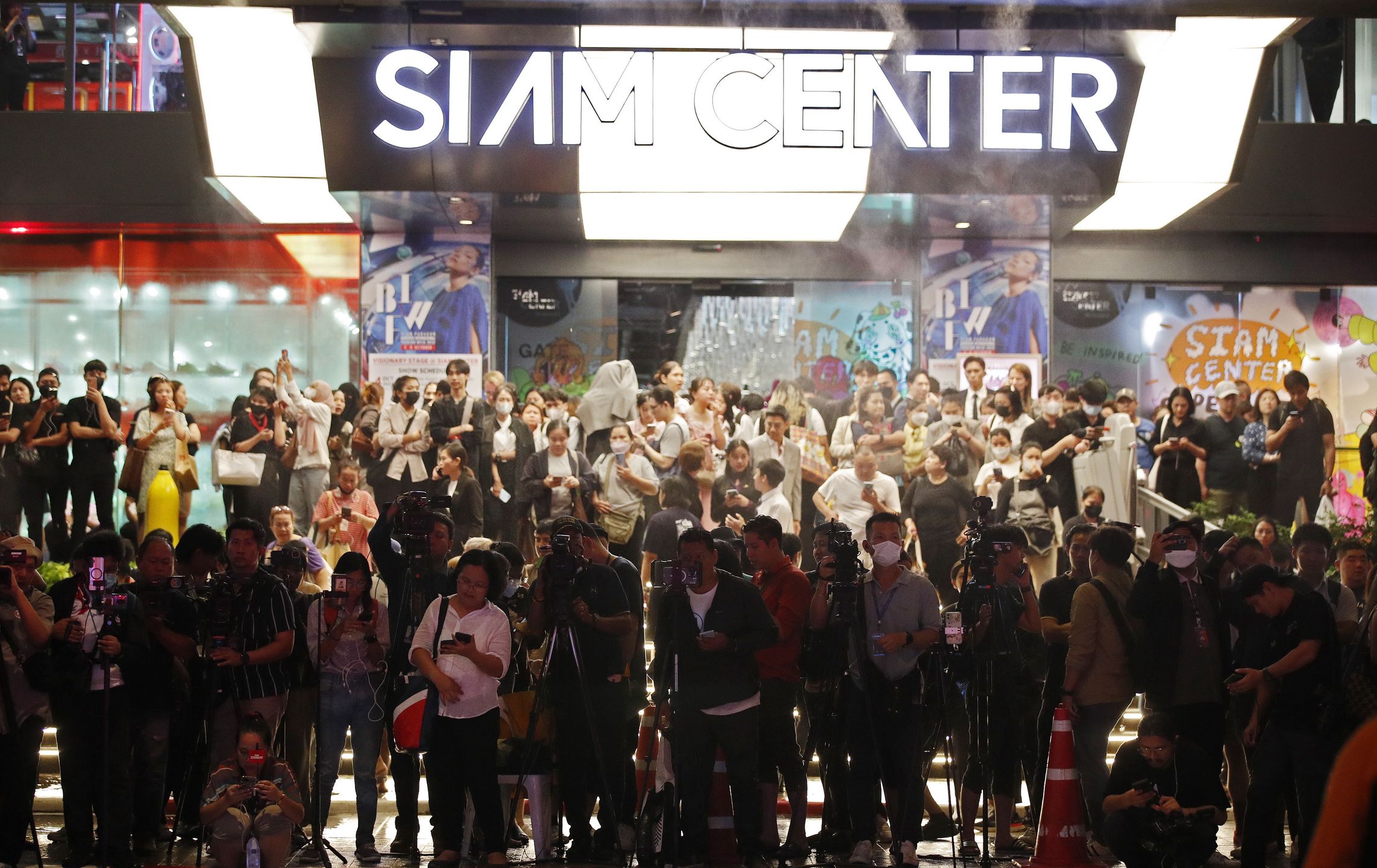 Members of the media and evacuated shoppers look from a building opposite to the Siam Paragon Mall following gunshots in Bangkok, Thailand, 03 October 2023. Thai police said the suspected gunman was arrested, while emergency services confirmed at least three people were killed. EPA/RUNGROJ YONGRIT Dostawca: PAP/EPA.