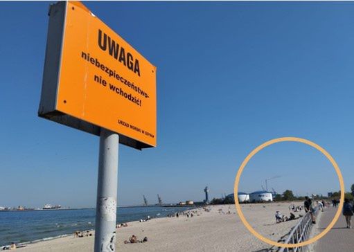 Ludzie przeskakują przez ogrodzenia na plażę