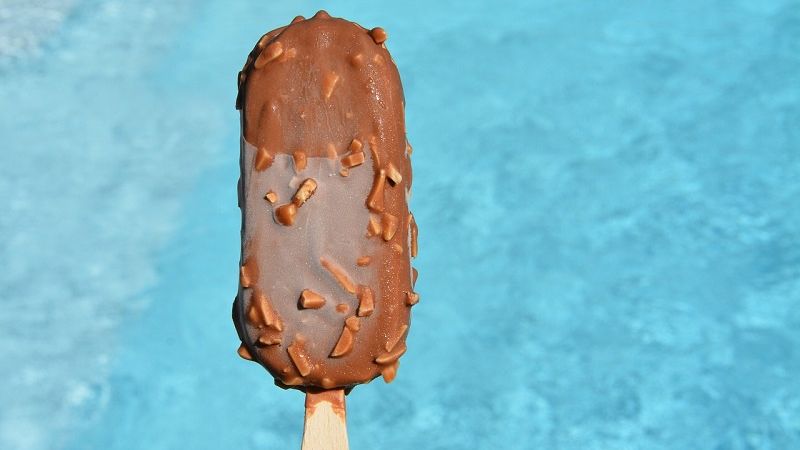 lody na patyku na tle basenu z woda
