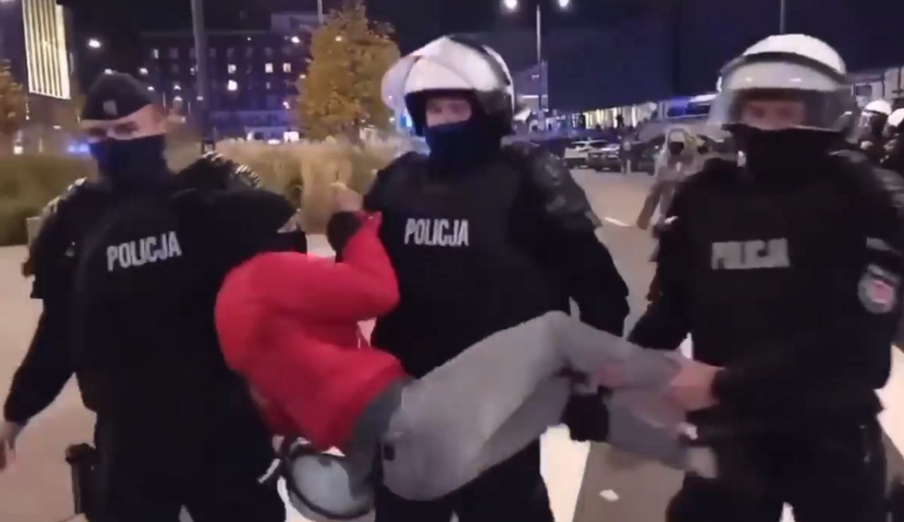 Trzech policjantów przenosi kobietę jak przedmiot. "Za to, że sobie stałam po prostu?"