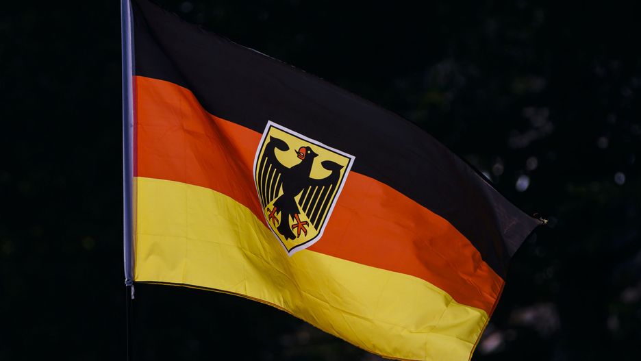 BERLIN, GERMANY - AUGUST 21: Symbolic photo. The national flag of the Federal Republic of Germany with a federal eagle blows in the wind in the backlight on August 21, 2024 in Berlin, Germany. (Photo Illustration by Thomas Trutschel/Photothek via Getty Images)