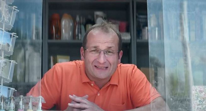 Robert Górski w plażowym kiosku zachęca do rejestrowania  numerów w Orange na kartę