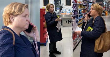 Zamyślona Katarzyna Bosacka buszuje po supermarkecie z telefonem przy uchu i z plikiem kartek w rękach