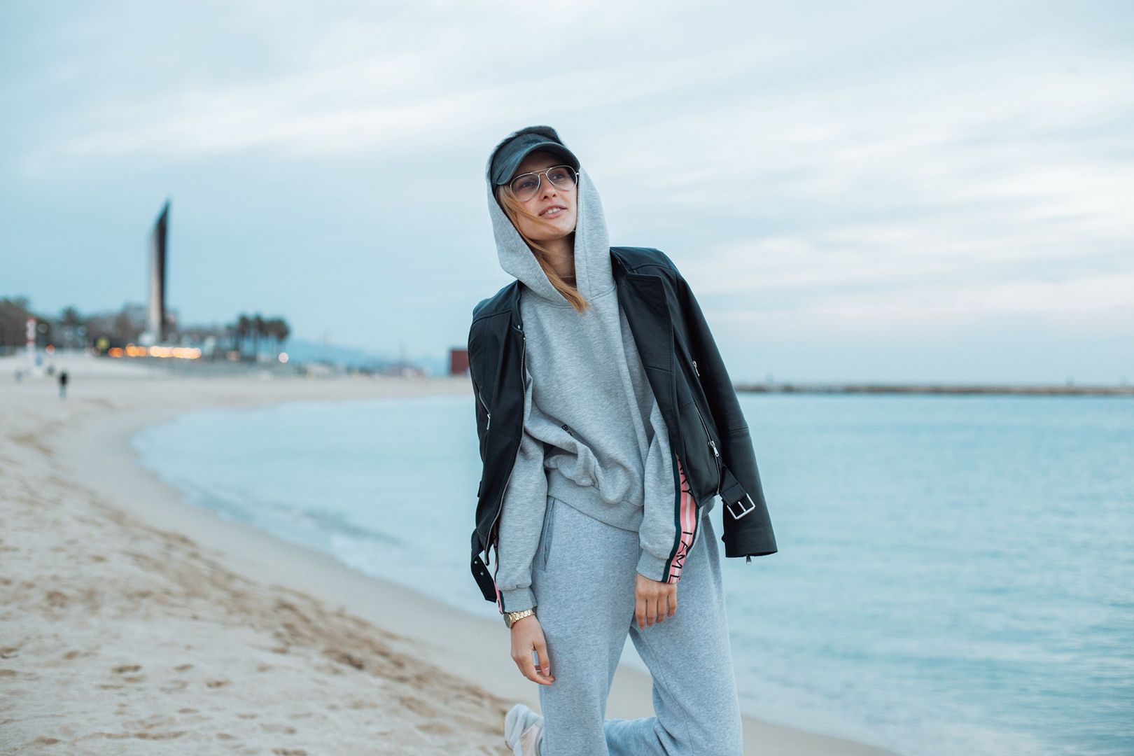 Happy and natural beauty young pretty and attractive woman or teenager wears grey hoodie and sweatpants during workout at beach seaside laughs naturally to camera, during fashion photoshoot influencerfitness,   girl,   woman,   sport,   music,   background,   person,   tracksuit,   casual,   one,   sportswear,   young,   adult,   cloudy,   concept,   confident,   cool,   exercising,   female,   fit,   clothing,   clothes,   gray,   gym,   hair,   hands,   happy,   in,   jogger,   leisure,   lifestyle,   listening,   long,   looking,   trendy,   caucasian,   outdoor,   pants,   pensive,   people,   fashion,   pockets,   portrait,   posing,   model,   pretty,   relaxation,   relaxed,   sweatpants,   runner