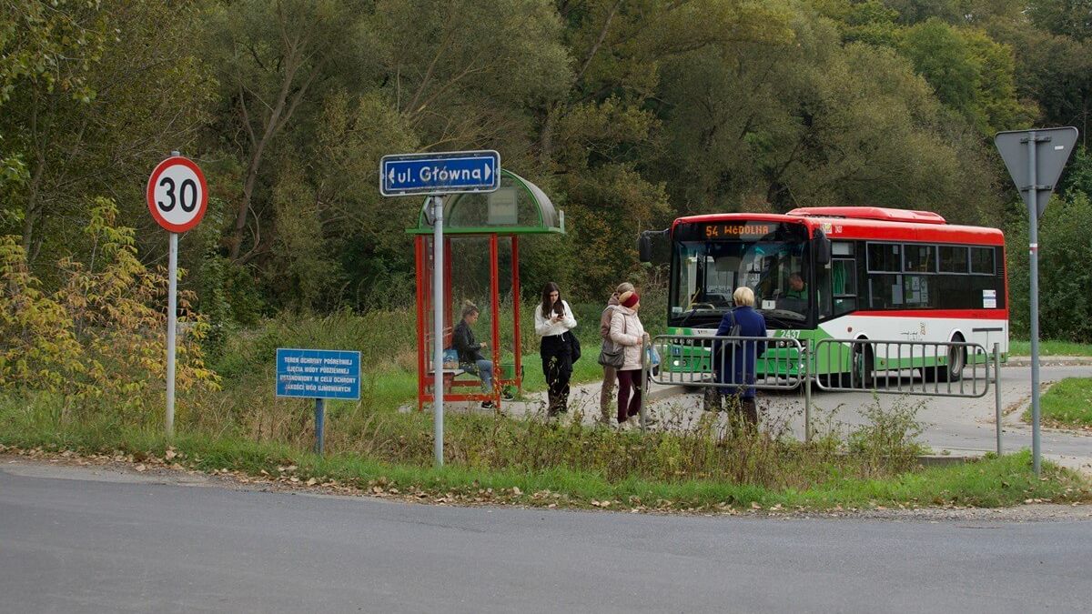 Pasażerowie oczekujący na autobus na przystanku przy ul. Głównej