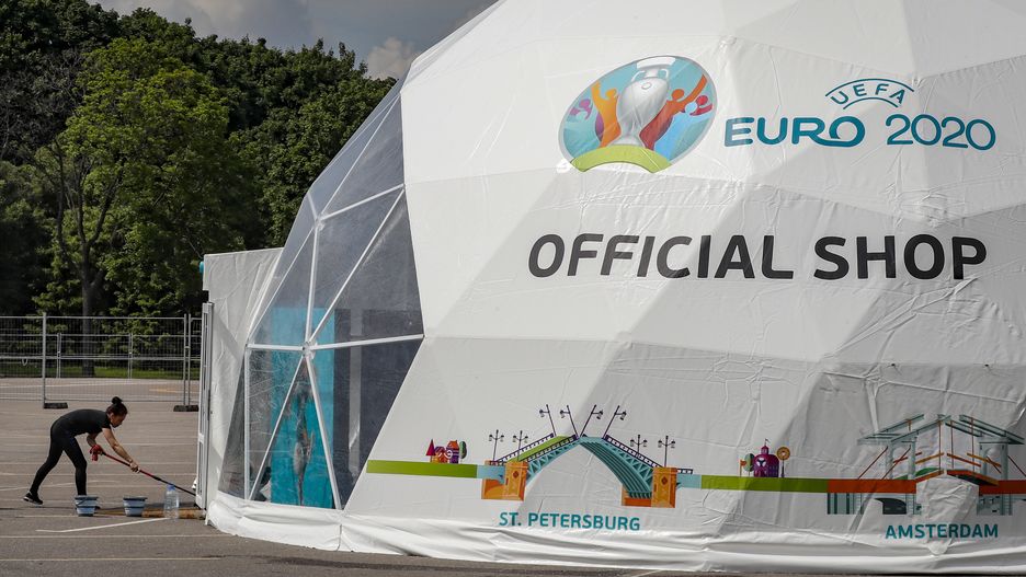 epa09254805 A woman cleans near tent of the official shop for EURO 2020 at the construction of UEFA EURO 2020 Fan Zone in Moscow, Russia, 08 June 2021. The UEFA EURO 2020 soccer tournament will be held from 11 June to 11 July 2021.  EPA/YURI KOCHETKOV Dostawca: PAP/EPA.
