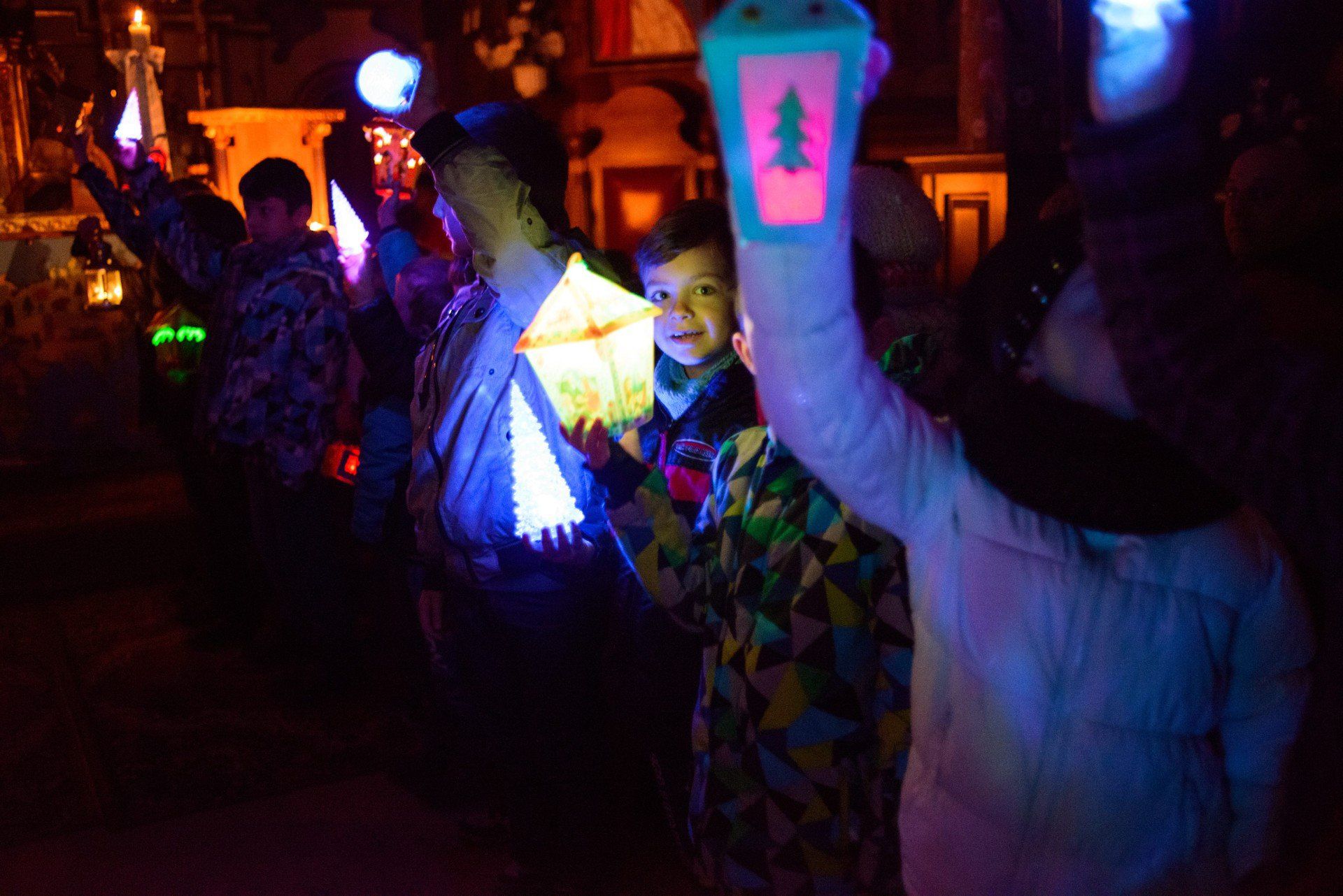 Ciemny kościół rozświetlają przyniesione przez dzieci światełka