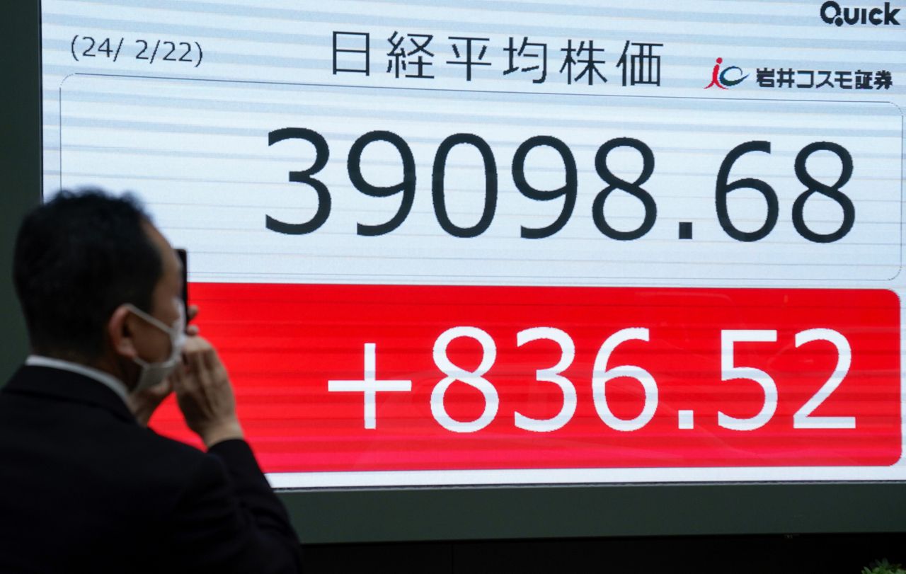A pedestrian takes a commemorative photo of a display showing the new record high closing of the Nikkei Stock Average in Tokyo, Japan, 22 February 2024. Tokyo's stock benchmark rose 836.52 points, closing at 39,098.68, to break the 38,915.87 points marked at the end of December 1989. EPA/KIMIMASA MAYAMA Dostawca: PAP/EPA.