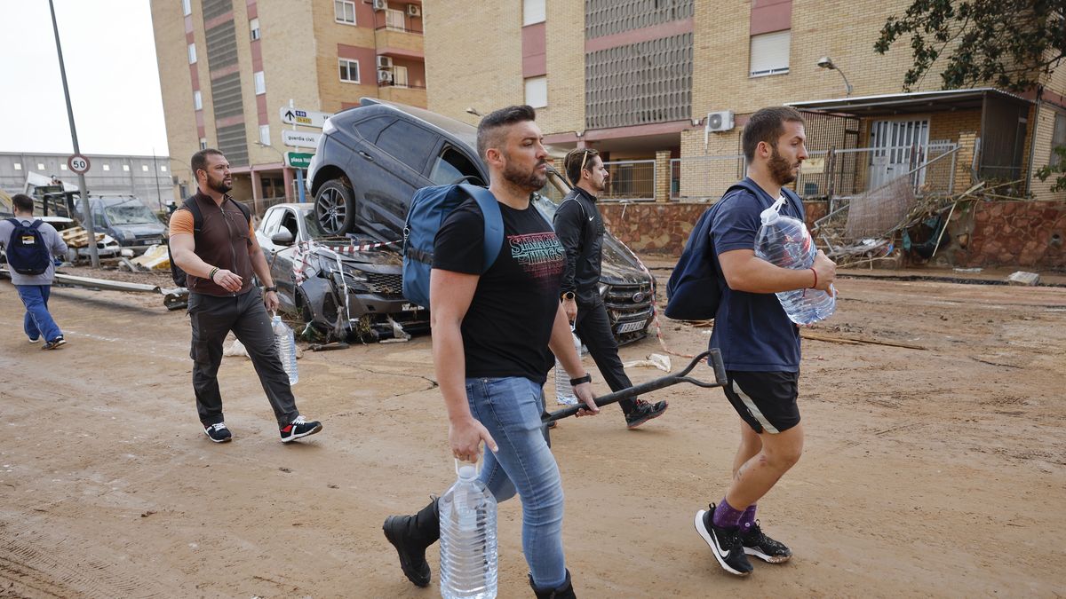 Residents carrying water bottles walk past damaged vehicles on a street in the flood-hit municipality of Paiporta, in the province of Valencia, Spain, 31 October 2024. At least 95 people died in the province of Valencia and neighboring provinces following floods caused by the DANA (high-altitude isolated depression) phenomenon impacting the eastern part of the country. EPA/BIEL ALINO Dostawca: PAP/EPA.