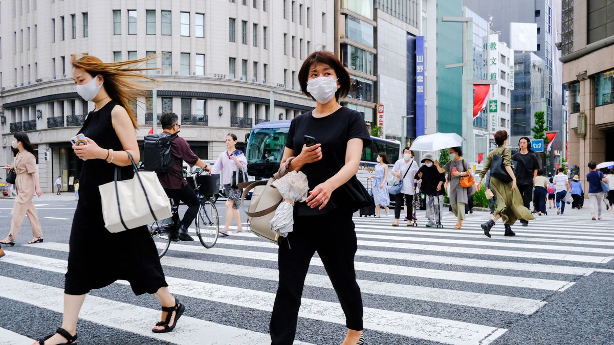 TOKYO, JAPAN - 2022/08/24: Pedestrians wearing face masks as a preventive measure against the spread of covid-19 walk along the Streets of Ginza shopping district in Tokyo. (Photo by James Matsumoto/SOPA Images/LightRocket via Getty Images)