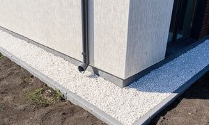 Białe kamyki wokół domu. Ozdoba czy genialna tarcza na deszcz?