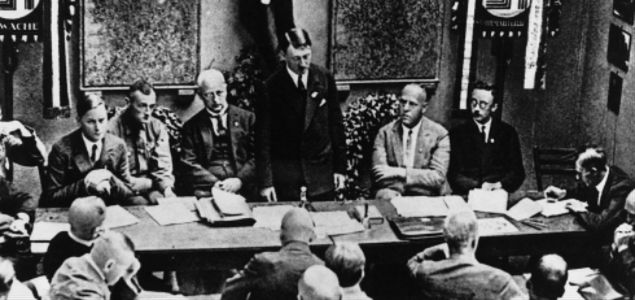 Hitler przemawia z okazji ponownej legalizacji NSDAP. Obok niego (po prawej stronie) siedzą Gregor Strasser i Heinrich Himmler, luty 1925 r. 