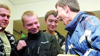 Uczniowie Liceum nr 9 w Katowicach, zwiedzający gmach NBP, dźwigają sztabę złota o wadze 12,5 kg
