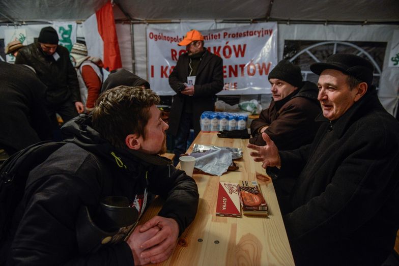 Warszawa, 19.02.2015. Rolnicy protestujący przed KPRM przygotowują się do spędzenia tam nocy, rozstawiony jest namiot i kuchnia polowa, przywieziono drewno, worki z ziemniakami i cebulą.