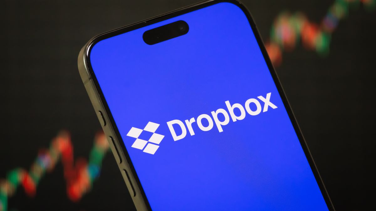 CHONGQING, CHINA - FEBRUARY 16:  In this photo illustration - The Dropbox logo is displayed on a smartphone screen in front of a stock chart showcasing Dropbox's financial performance, core businesses in cloud storage, file sharing, document management, and collaboration tools, as well as broader trends in the cloud computing and stock market industries on February 16, 2025, in Chongqing, China. (Photo by Cheng Xin/Getty Images)