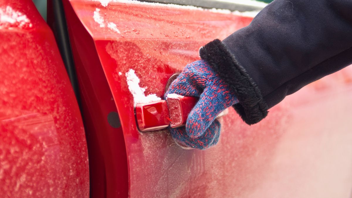 Kobieta otwiera zimą drzwi auta