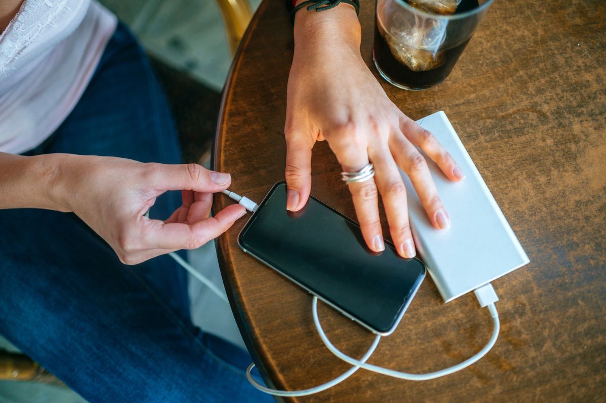 The woman plugs the phone into the charger.