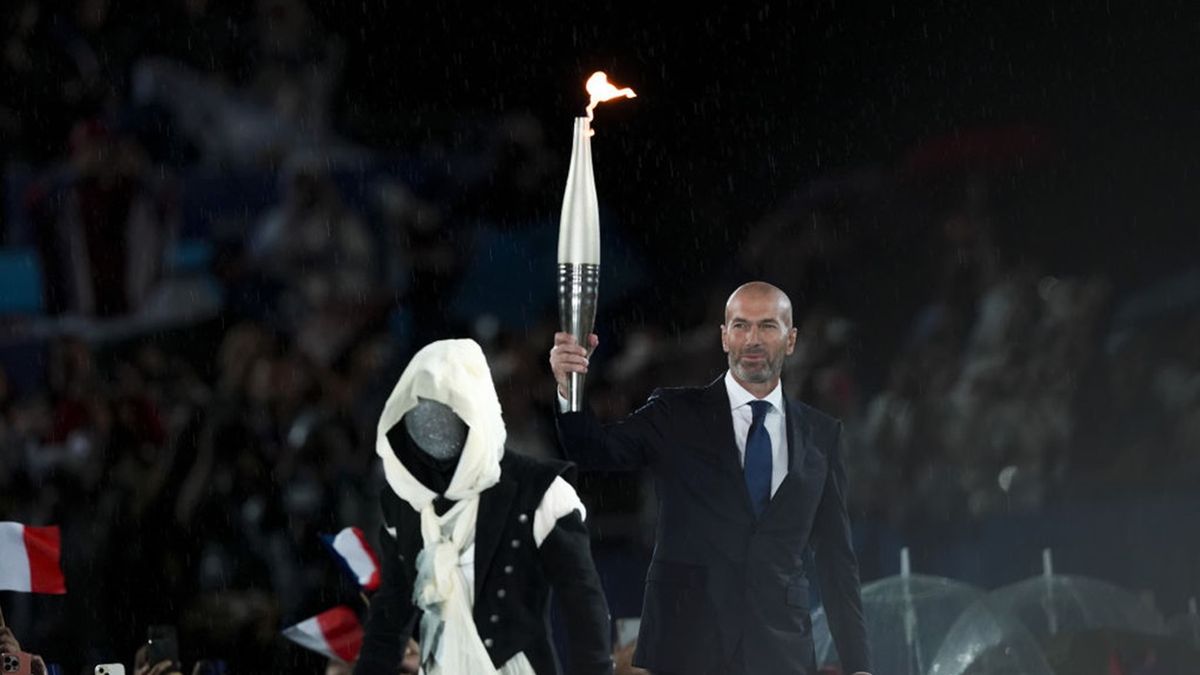 Getty Images / Mustafa Ciftci/Anadolu / Na zdjęciu: Zinedine Zidane przejął olimpijski ogień od zamaskowanej postaci