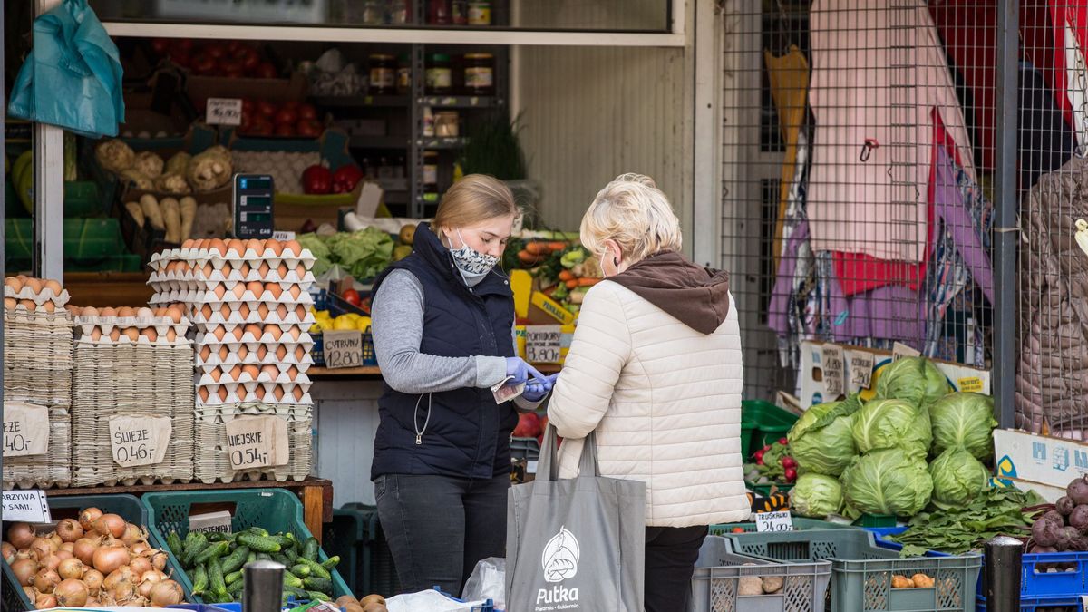 Na zdjęciu targ w Warszawie. Pani płaci za swoje zakupy ekspedientce