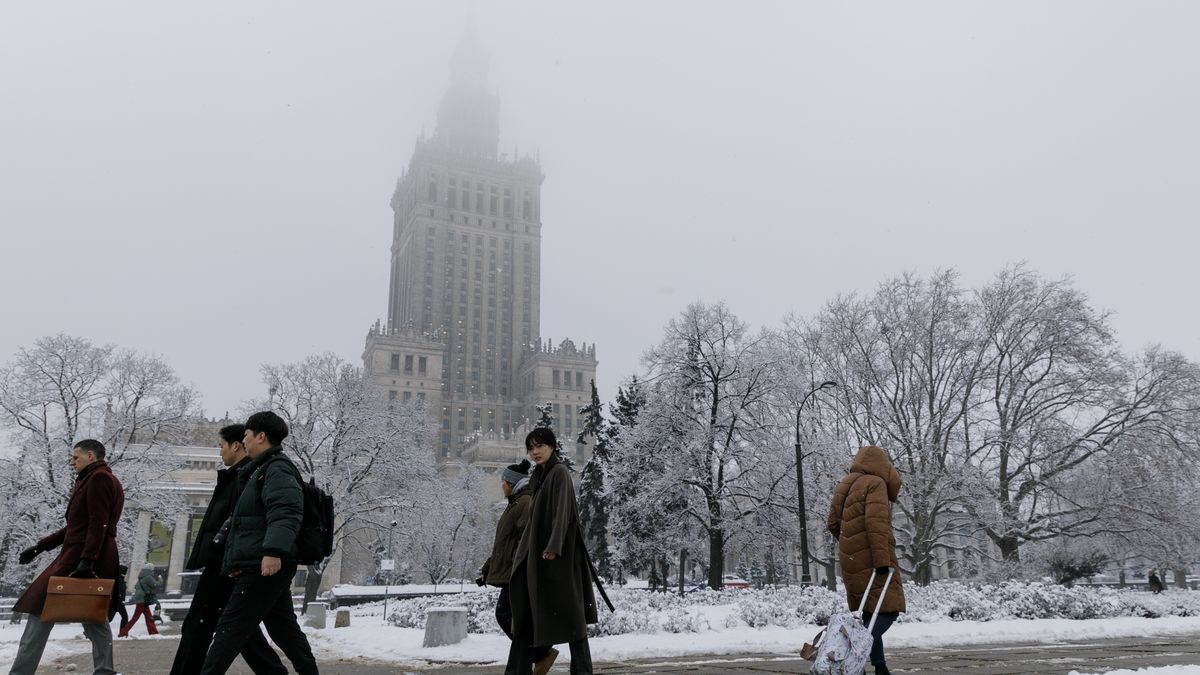 WARSAW, POLAND - 2026/01/28: People walk past the Palace of Culture and Science in central Warsaw. Snowfall overnight covered the city streets in Warsaw. Pedestrians and commuters move through fresh snow as winter weather settles in the capital. (Photo by Volha Shukaila/SOPA Images/LightRocket via Getty Images)
