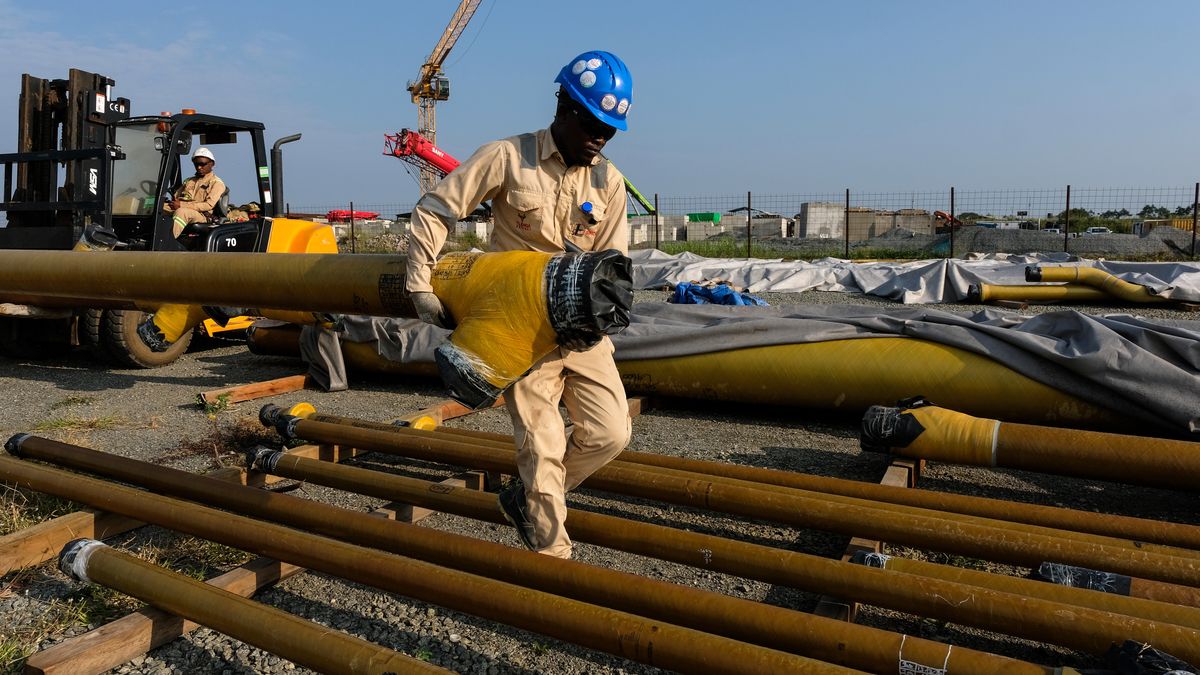 BULIISA, UGANDA - AUGUST 14: Sinopec employees offloading water pipes during construction of the Central Processing Facility at Tilenga oilfield on August 14, 2025 in Buliisa, Uganda. Located on the northeastern shores of Uganda's Lake Albert and nestled within Murchison Falls National Park, the Tilenga oilfield project is operated by French energy giant TotalEnergies, in partnership with China National Offshore Oil Corporation (CNOOC) and the Uganda National Oil Company (UNOC). Chinese petroleum firm Sinopec has been contracted to complete construction of the site's Central Processing Facility (CPF) for the Tilenga's six oil fields and around 400 wells. The Tilenga operation forms a major part of the 1,443-kilometer (897 mile)East Africa Crude Oil Pipeline (EACOP), designed to link landlocked oil fields in Western Uganda to Tanzania's Tanga port on the Indian Ocean. The pipeline project has been mired in controversy, with majority stakeholders TotalEnergies facing accusations and legal battles over human rights abuses and environmental concerns. First oil was originally slated for production this year, but is now expected in 2026. (Photo by Hajarah Nalwadda/Getty Images)