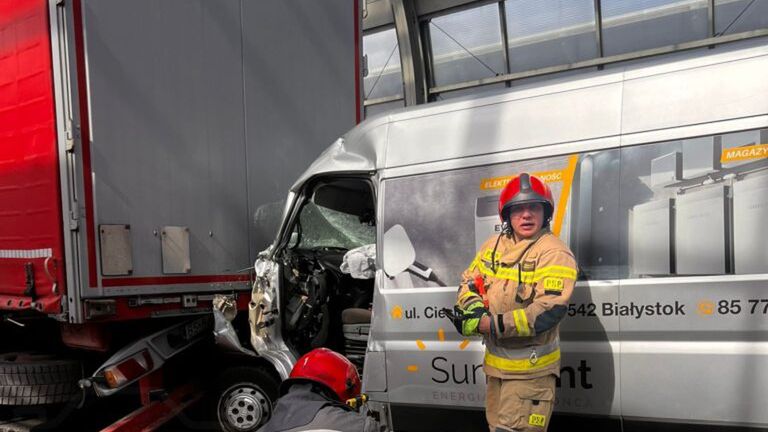 Strażacy w mundurach pracują przy wypadku drogowym, używając narzędzi hydraulicznych obok uszkodzonego pojazdu.