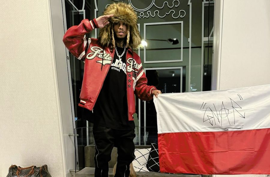 Amerykański raper pozuje z polską flagą stojąc na kobiecie