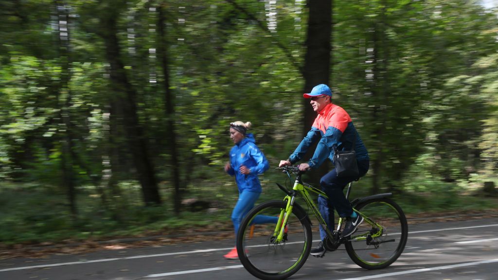 Getty Images / Vladimir Gerdo / Na zdjęciu: kobieta biegająca i mężczyzna na rowerze