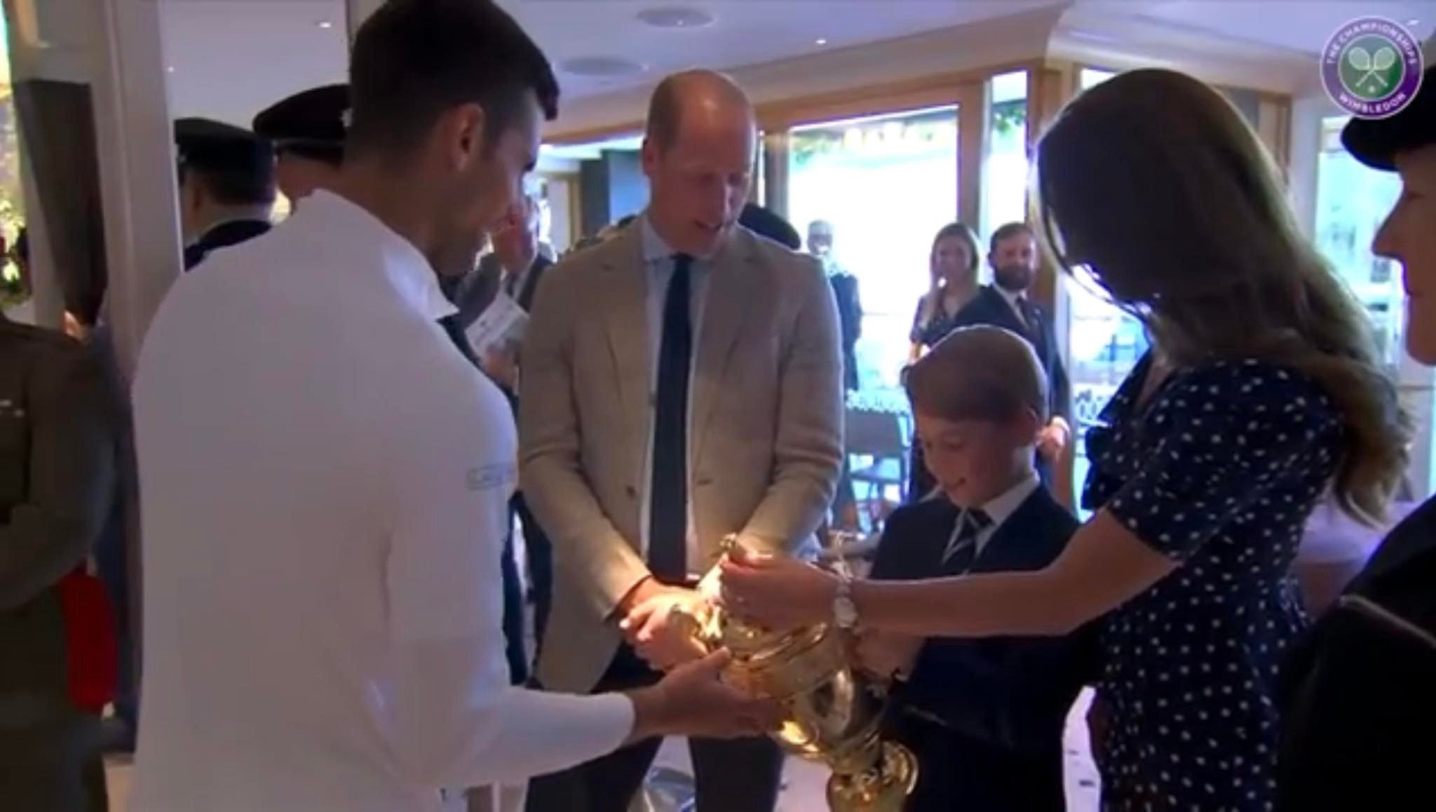 Książę George trzyma trofeum zwycięscy Novaka Djokovića
