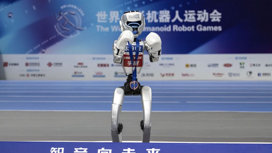 BEIJING, CHINA - AUGUST 17: A humanoid robot wears a medal during the ceremony after the kickboxing final  at the World Humanoid Robot Games on August 17, 2025 in Beijing, China. China held the event from August 14-17, billed as the first of its kind.  (Photo by Kevin Frayer/Getty Images)