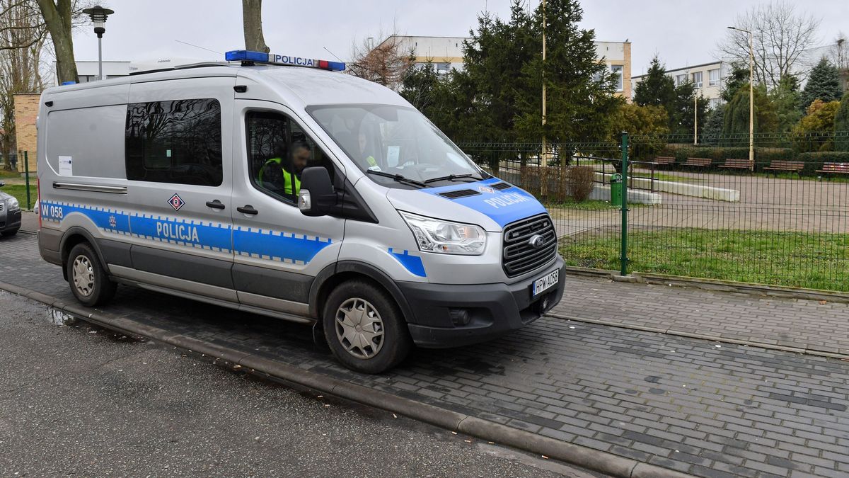 Policyjny radiowóz pod szkołą. Zdjęcie ilustracyjne