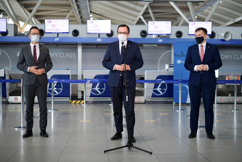 Marcin Horała (w środku) o wsparciu lotnisk poinformował w warszawskim porcie lotniczym.