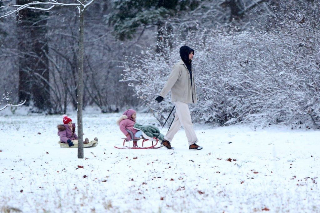 Maciej Pela ciągnie córki na sankach