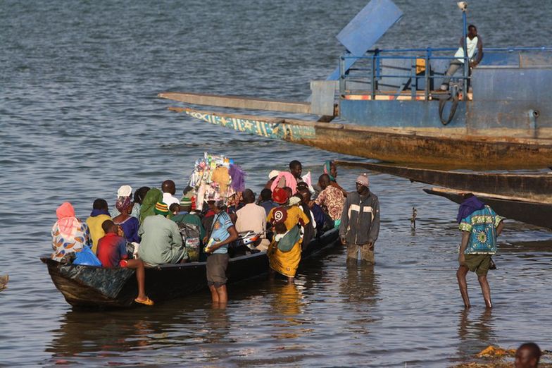 Pasażerowie wsiadają do łodzi na rzece Niger