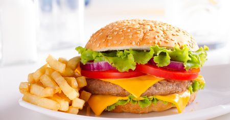Powiększony cheeseburger z przyprawami, warzywami i majonezem