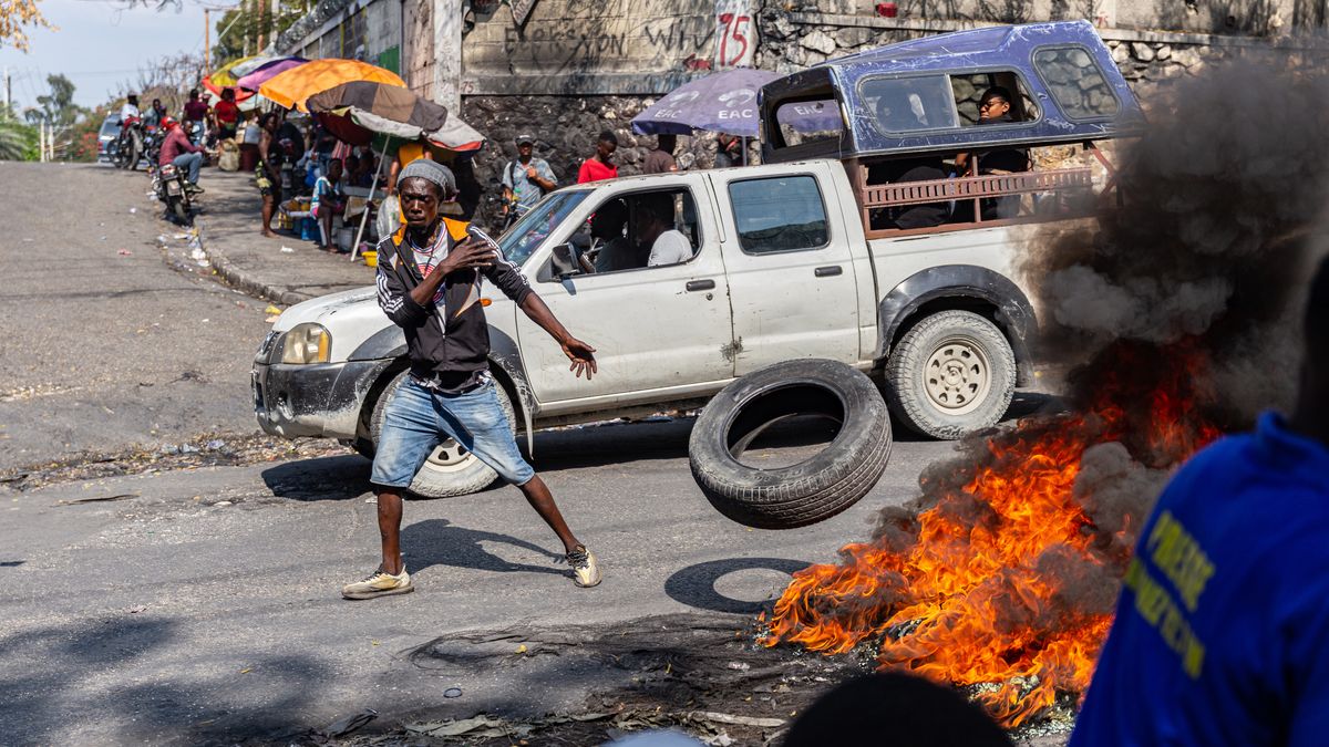 PORT-AU-PRINCE, HAITI- MARCH 12: A man sets a tire on fire during a demonstration against CARICOM for the decision following the resignation of Haitian Prime Minister Ariel Henry as representatives of the Caribbean Community (CARICOM) and Haitian actors made an agreement for political transition in Haiti it a historic decision that was made by the formation of a seven-member Presidential Council (CP), and the Haitian government on Tuesday extended the night-time curfew and state of emergency in the capital of Port-au-Prince for a month amid a wave of violence triggered by armed groups in Port-au-Prince, Haiti, on March 12, 2024. (Photo by Guerinault Louis/Anadolu via Getty Images)