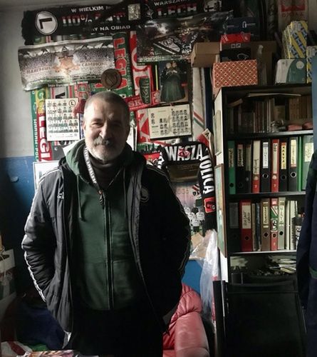 Bogusław Łobacz na tle ściany z pamiątkami