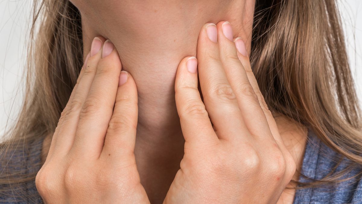 Woman with throat sore is holding her aching throat
Woman with throat sore is holding her aching throat - body pain concept
andriano_cz