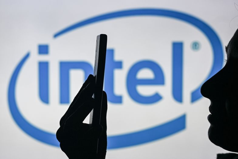 EDMONTON, CANADA - APRIL 28:
An image of a woman holding a cell phone in front of the Intel logo displayed on a computer screen, on April 29, 2024, in Edmonton, Canada. (Photo by Artur Widak/NurPhoto via Getty Images)