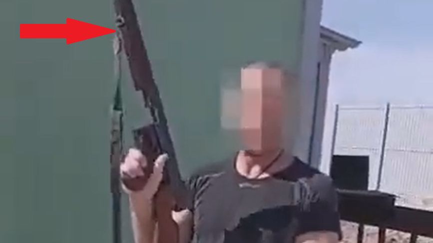 Rosjanin trzymający zabytkowy pistolet Thompson M1.