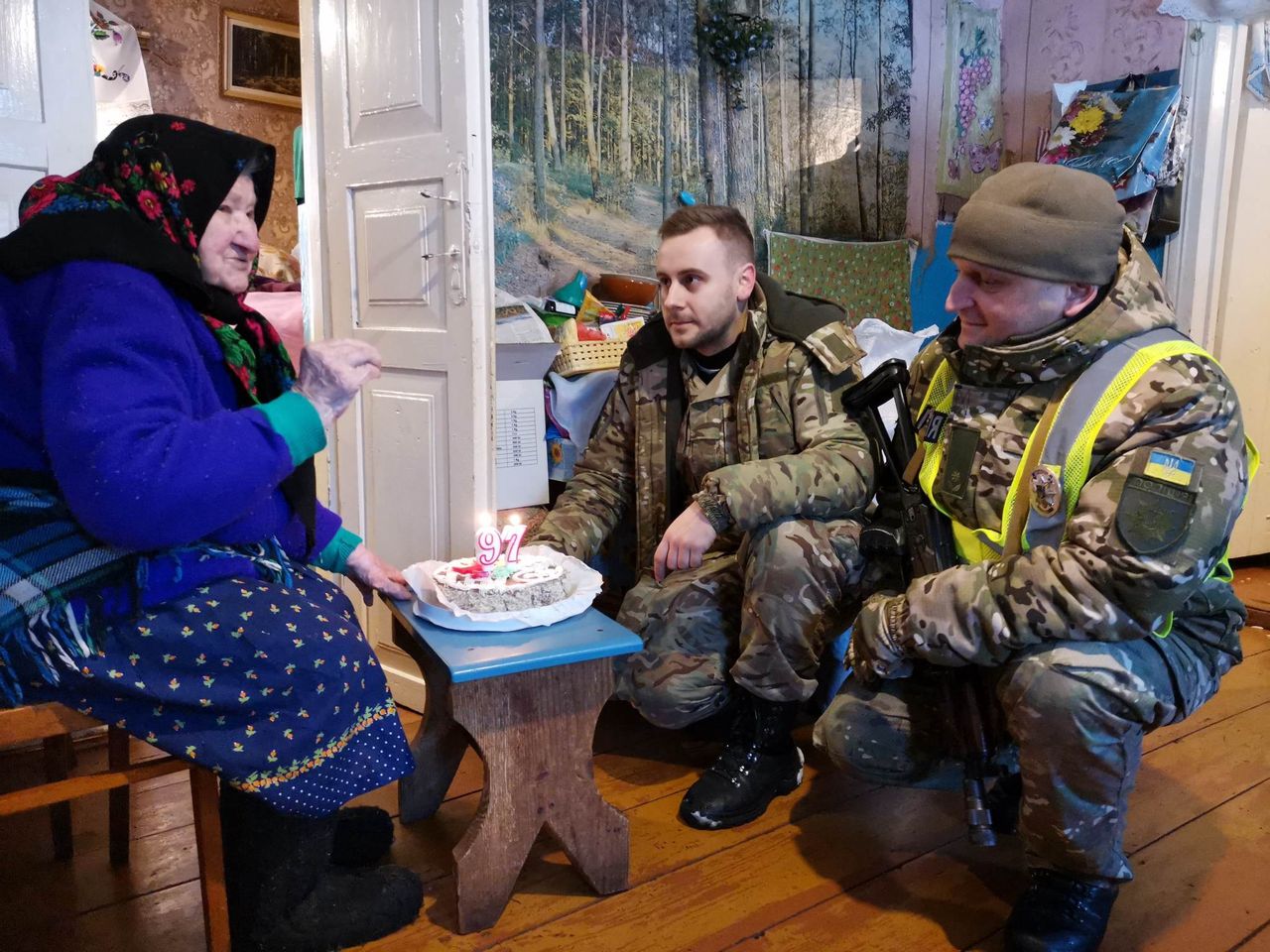 Krystian Machnik w obstawie policjanta składa babuszce Marii urodzinowe życzenia