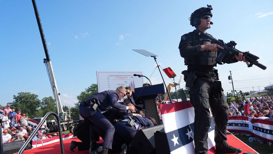 BUTLER, PENNSYLVANIA - July 13: Secret service agents cover former president Donald Trump during a campaign rally for former President Donald Trump at Butler Farm Show Inc. on Saturday, July 13, 2024 in Butler, Pa. Trump ducked and was taken offstage after loud noises were heard after he began speaking. 
(Photo by Jabin Botsford/The Washington Post via Getty Images)