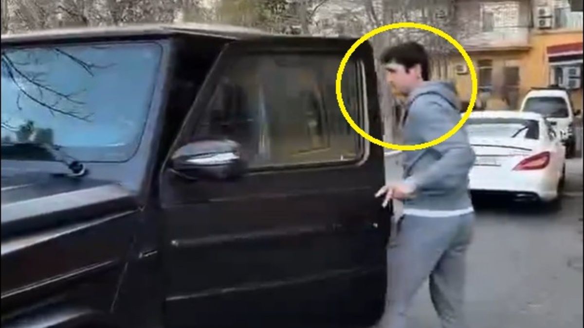 Abduqodir Husanov zagląda do wnętrza luksusowego samochodu